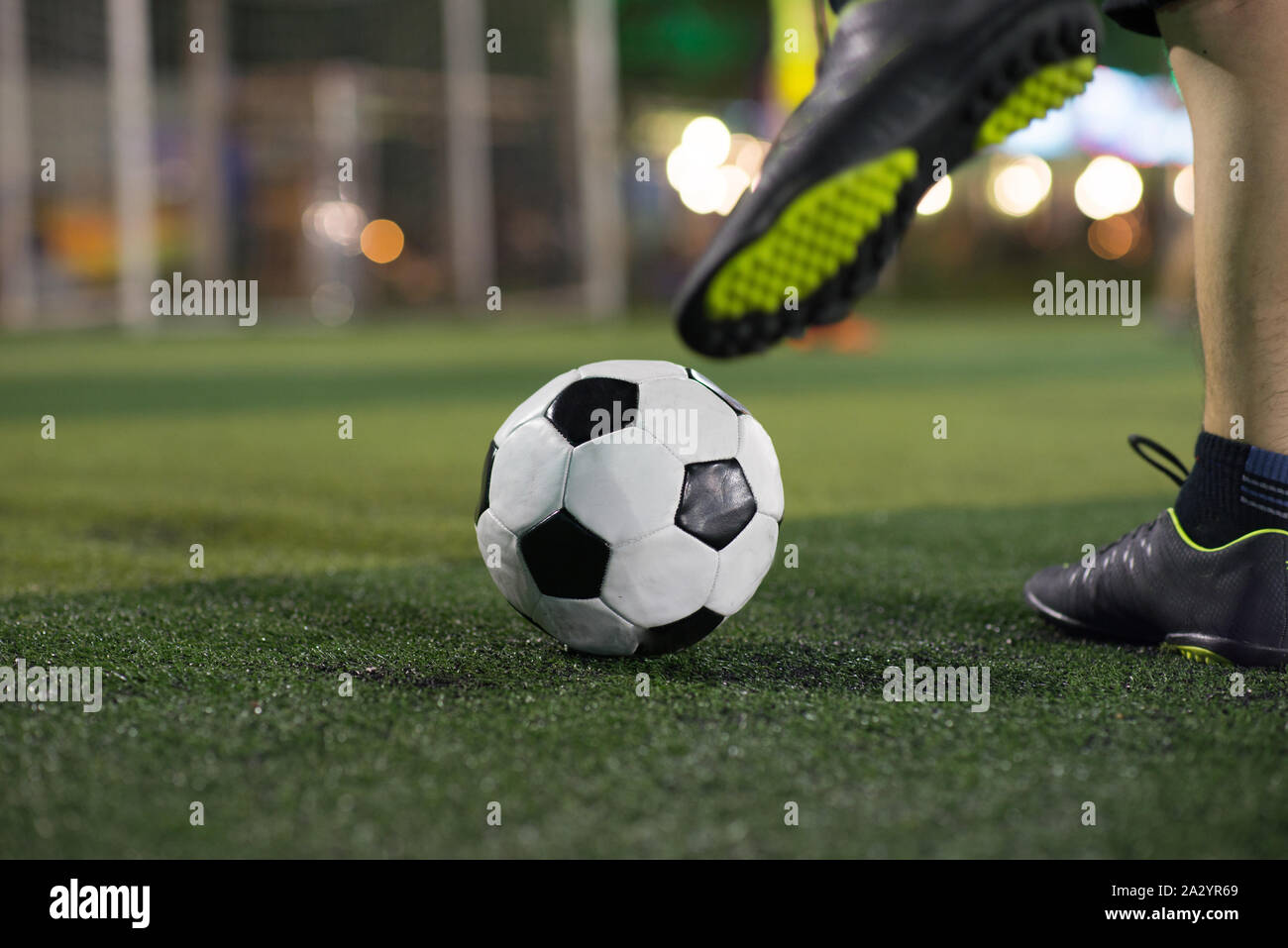 Soccer player foot kicking ball on football field Stock Photo Alamy