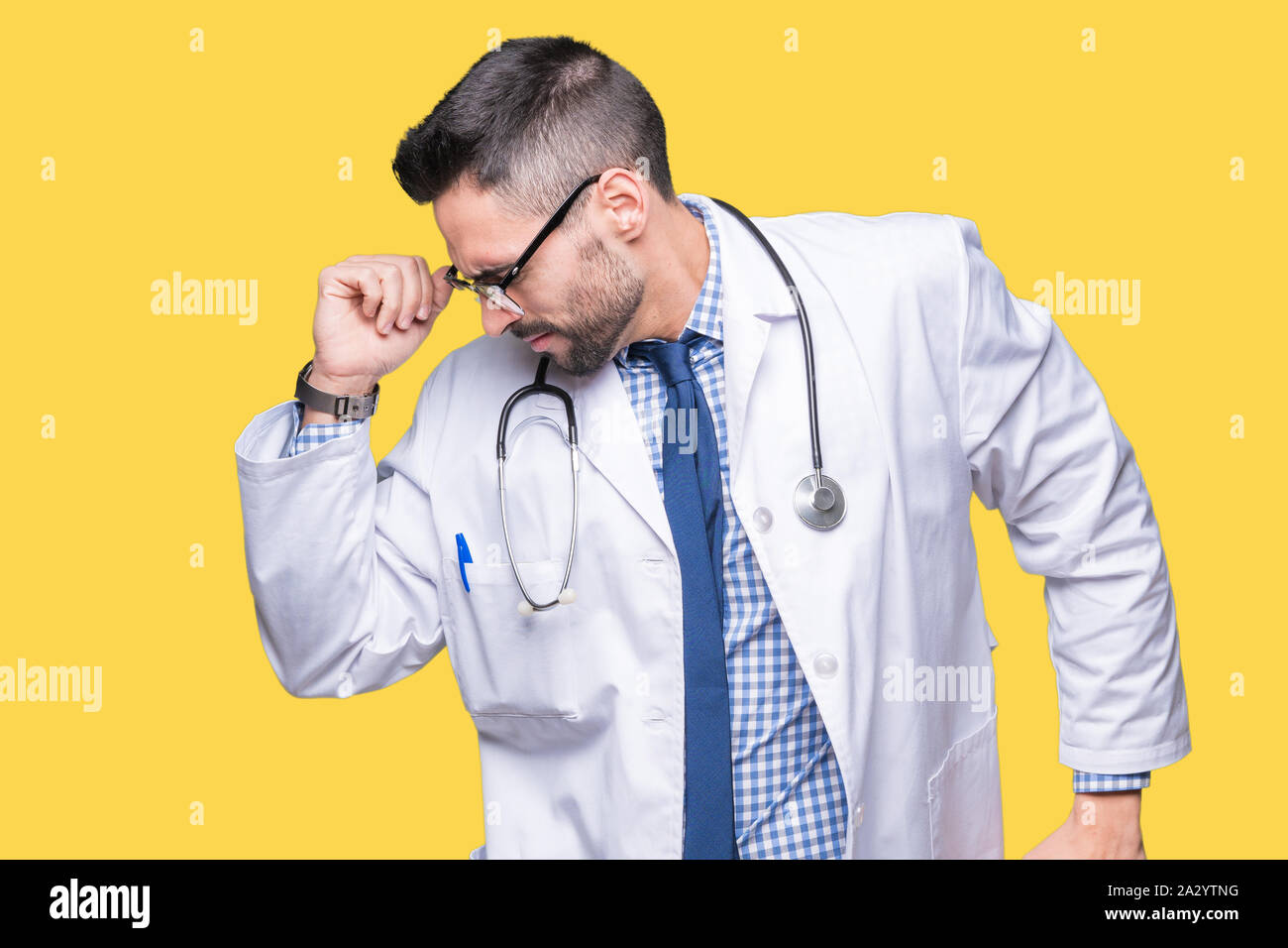 Handsome young doctor man over isolated background stretching back ...
