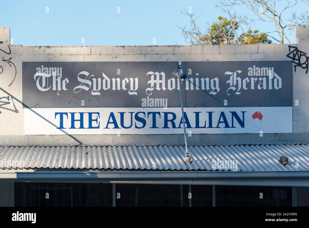 A large sign mounted above an old shop advertising an Australian (Sydney) newspaper Stock Photo