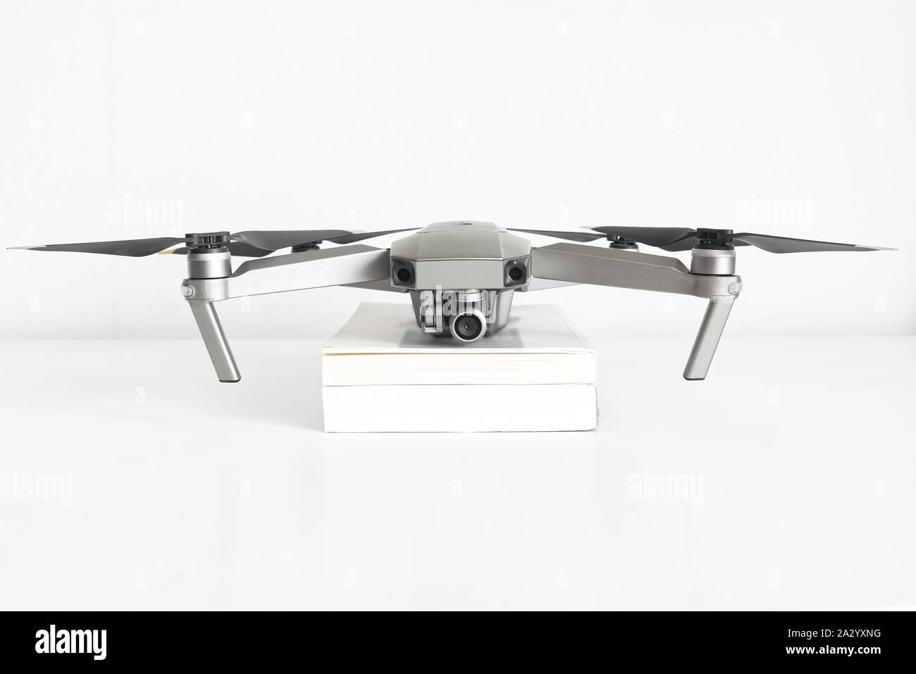 Drone on a book pile in a drone pilot classroom against a white background. No people and empty copy space for Editor's text. Stock Photo