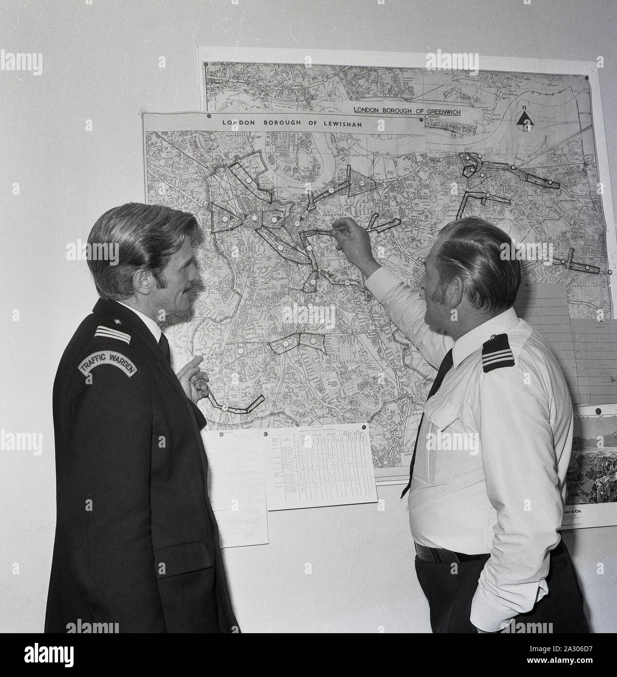 1972, historical, a newly recruited uniformed male traffic warden being shown his street area on a map on a wall by his senior officer, Lewisham, London, England, UK. Parking enforcement began in Britain in September 1960 when the first traffic wardens appeared on the streets of Westminster to issue fines to motorists on behalf of the Metropolitan Police. Stock Photo
