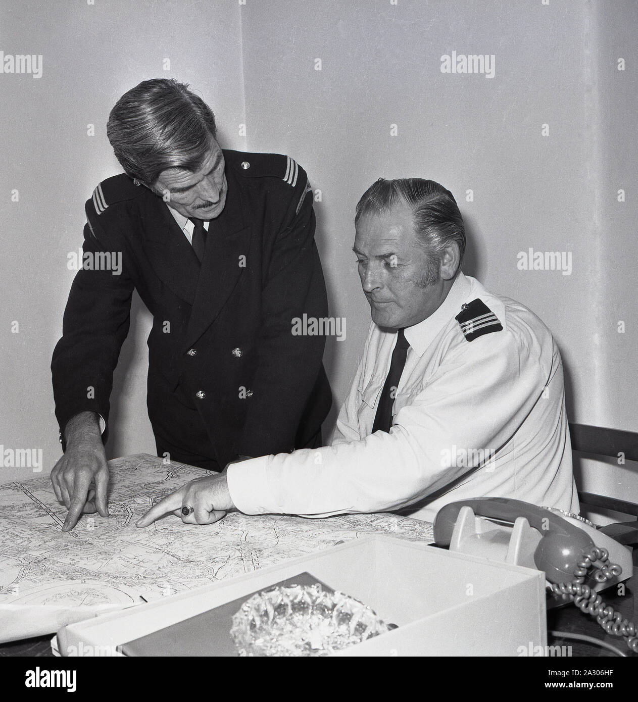 1972, historical, a uniformed male traffic warden looking at a street map with his senior officer, Lewisham, London, England, UK. Parking enforcement began in Britain in September 1960 when the first traffic wardens appeared on the streets of Westminster to issue fines to motorists on behalf of the Metropolitan Police. Stock Photo