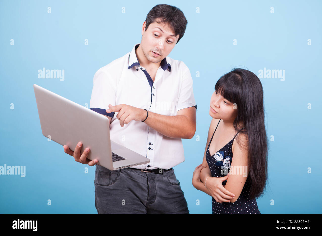 interracial asian wife Caucasian male pointing at laptop and consulting with his asian wife.  Interracial couple Stock Photo - Alamy
