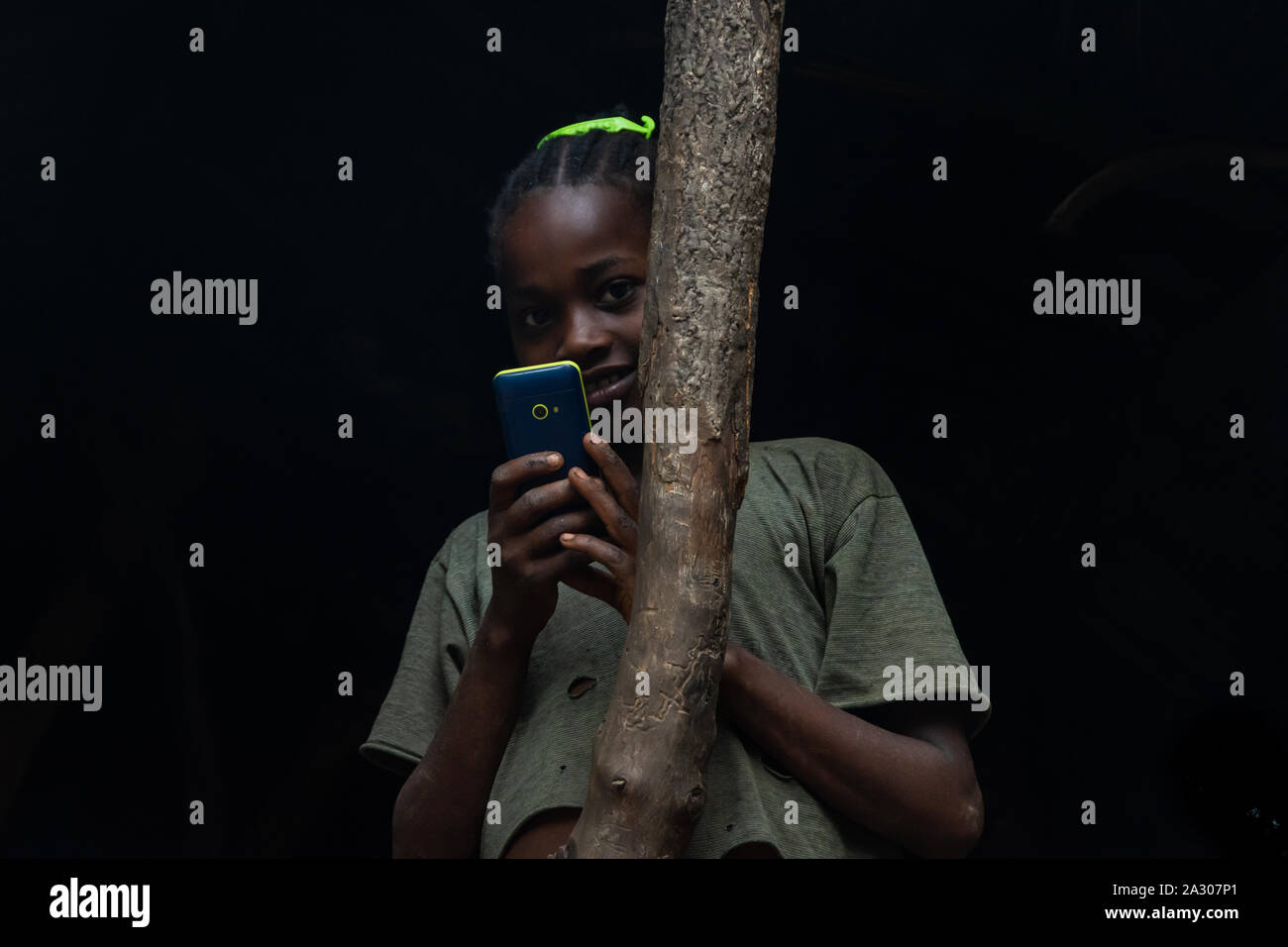 Jinka, Ethiopia - Nov 2018: Young and shy Ethiopian girl taking a photo wit...