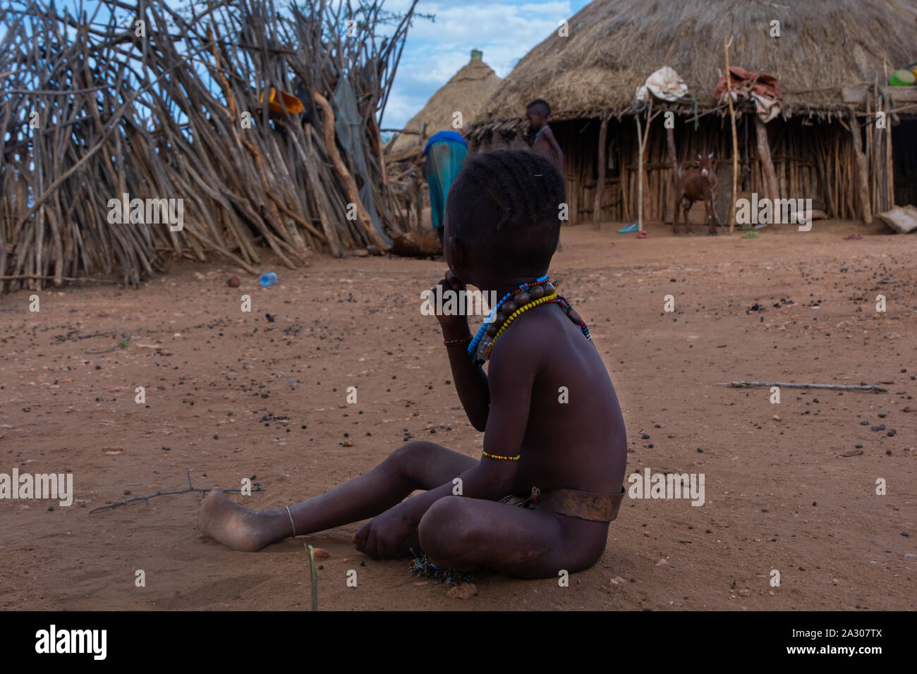 Turmi, Ethiopia - Nov 2018: Young Hamer tribe kid playing next to the house, Omo valley Stock Photo