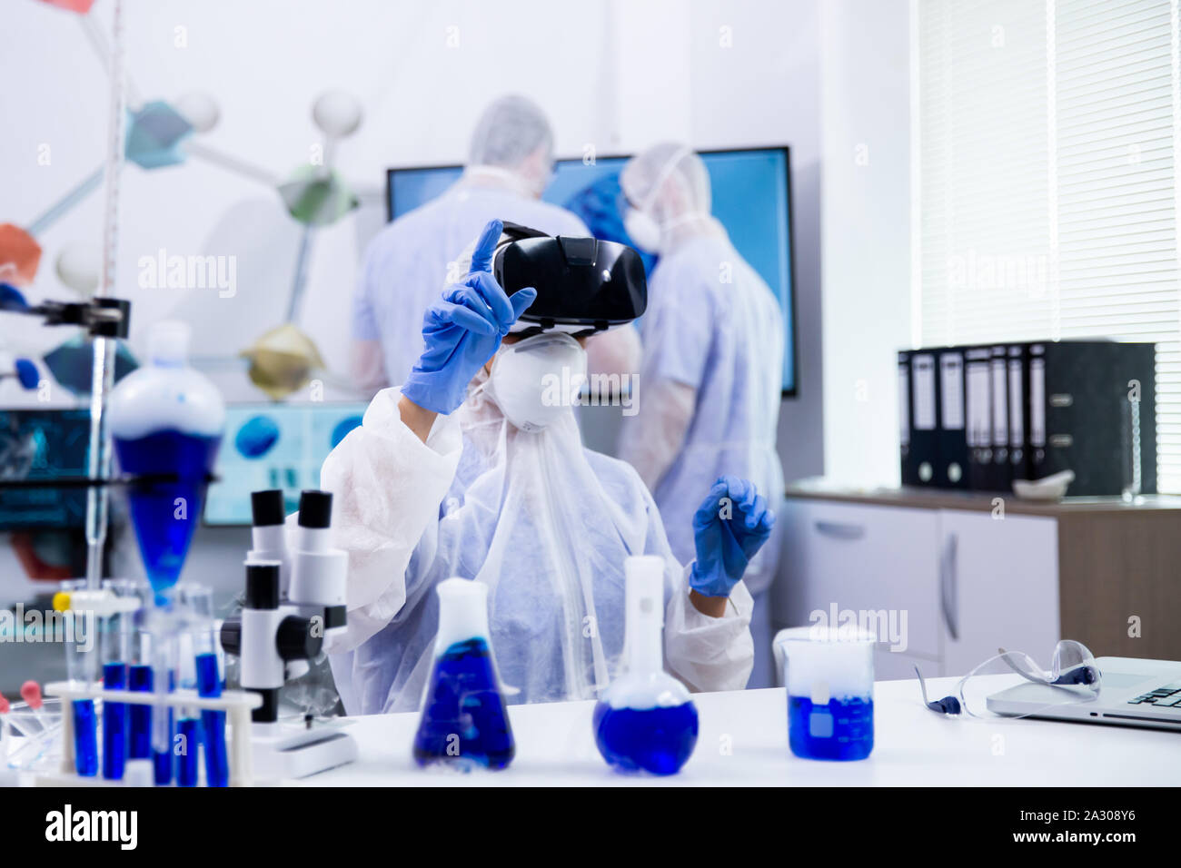 Female scientist wearing virtual reality headset and looking up in a ...