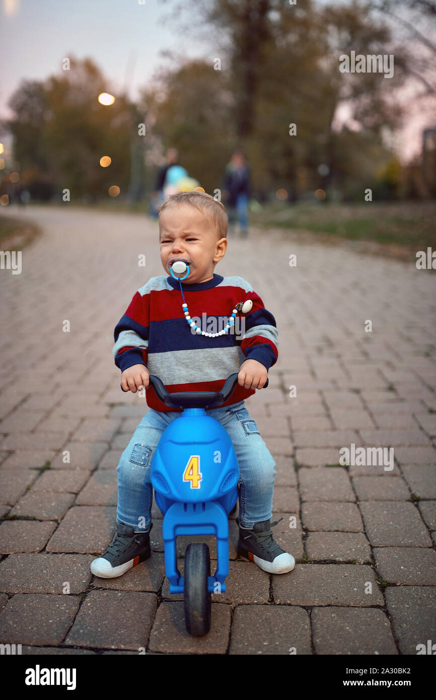 Crying little boy on bike. Family, childhood, season and people concept. Stock Photo