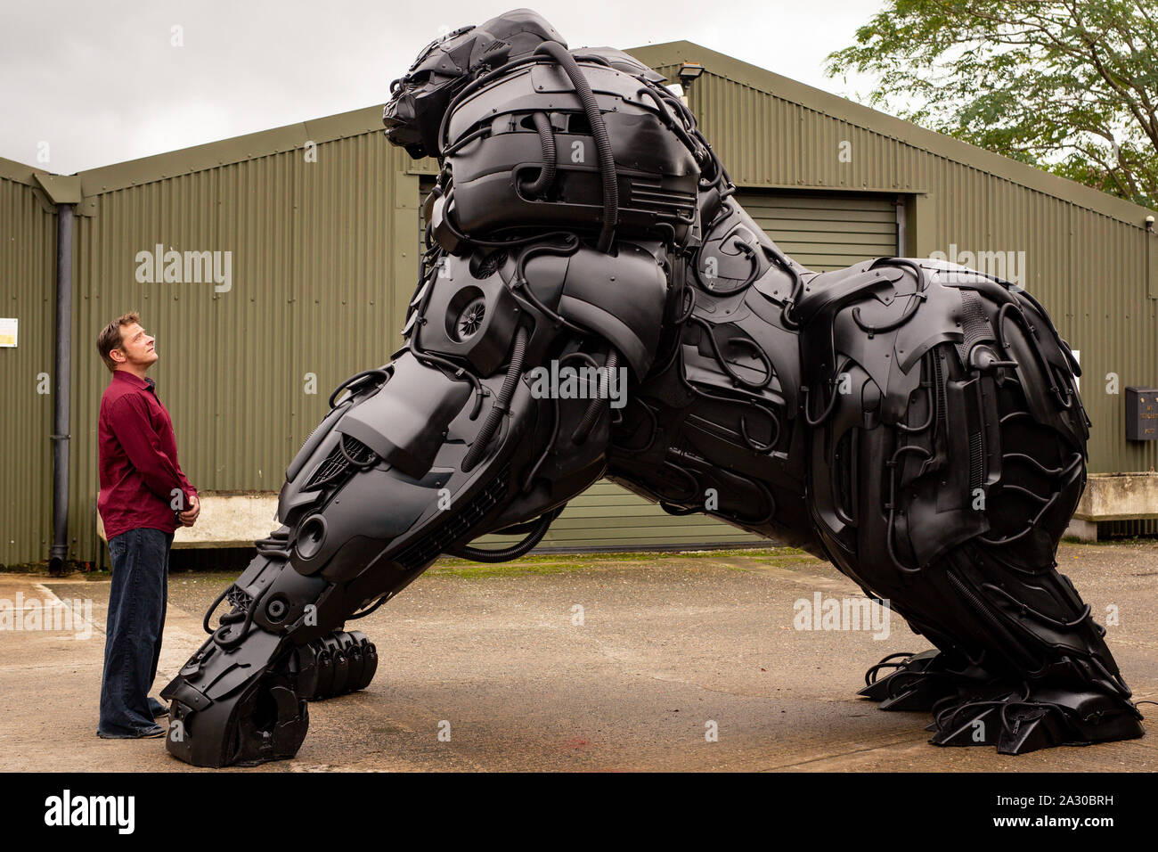 Sculptor Luke Kite with his 12ft sculpture of a gorilla, entitled 'Gorilla Apocalypse', created entirely from scrap car bumpers and panels discarded from only the last decade, on display at the British Ironwork Centre in Oswestry, Shropshire. PA Photo. Picture date: Friday October 4, 2019. The sculpture, named 'Bumper Joe' during production, serves as a protest against the perceived negative effects the global car industry has on the planet. Photo credit should read: Jacob King/PA Wire Stock Photo