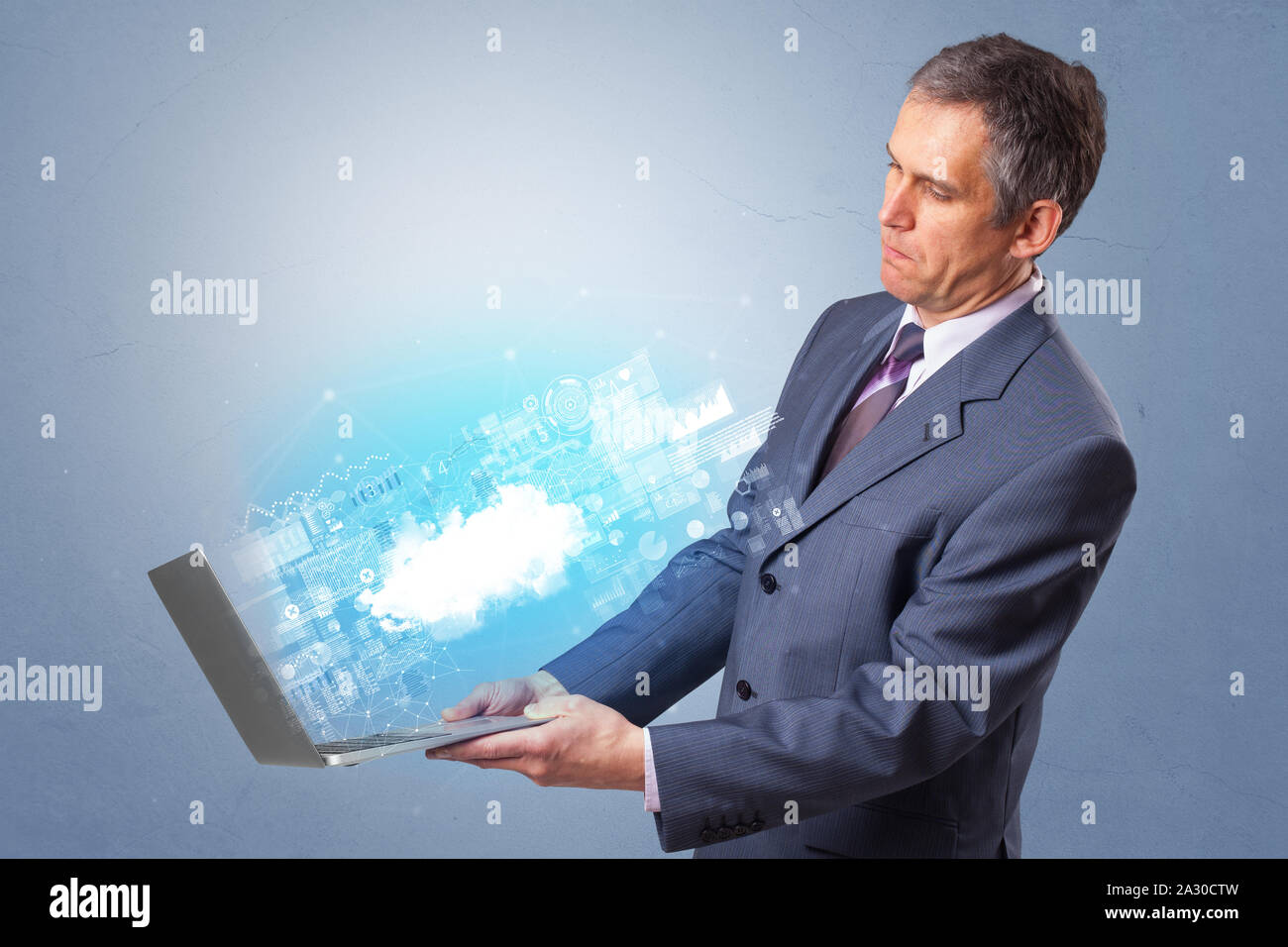 Man holding laptop projecting notifications, symbols and information based on cloud technology system Stock Photo