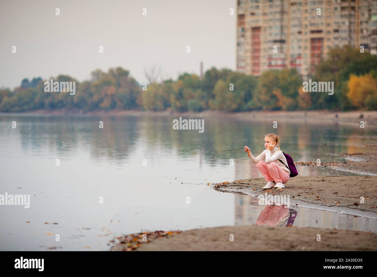 Young beautiful girl sitting on a river bank Stock Photo - Alamy