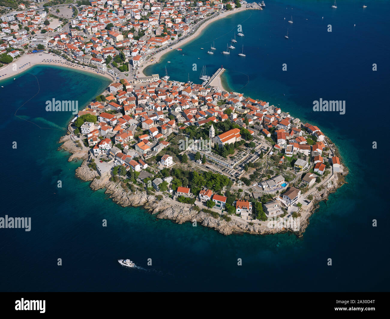 AERIAL VIEW. Medieval town built on a picturesque peninsula. Primošten, Dalmatia, Croatia. Stock Photo
