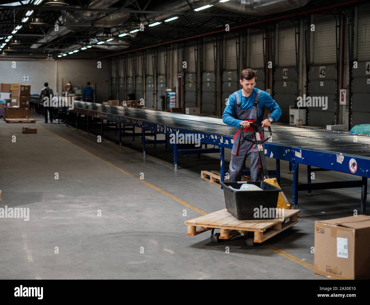 Warehouse worker with a pallet rack Stock Photo - Alamy