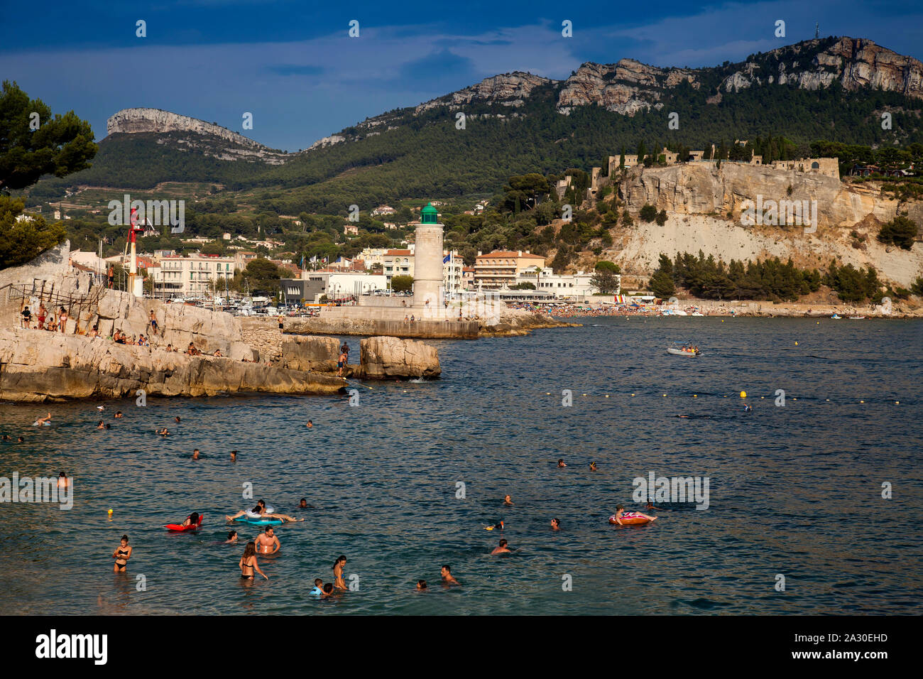Menschen baden am Strand, Plage Le Bestouan, im Hintergrund der Leuchtturm von Cassis,Bouches-du-Rhone, Provence-Alpes-Côte d’Azur, Südfrankreich, Fra Stock Photo