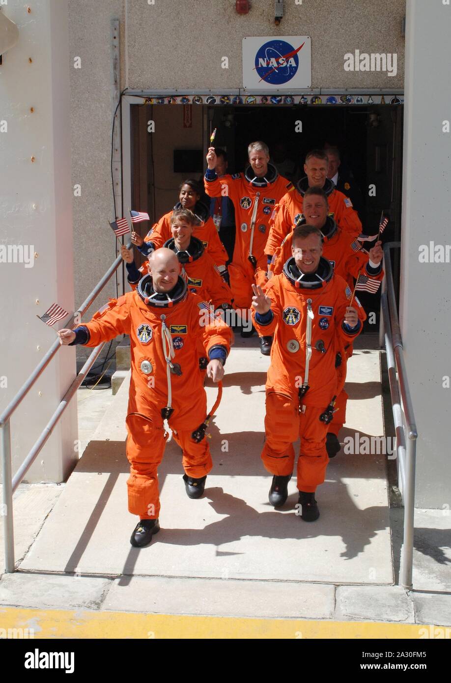 FILE: In this photo released by NASA, the STS-121 crew displays the spirit of the Fourth of July holiday with their flags and their eagerness to launch as they stride out of the Operations and Checkout Building at the Kennedy Space Center, Florida on July 4, 2006. Leading the way are Pilot Mark Kelly (left) and Commander Steven Lindsey (right). Behind them are Mission Specialists (second row) Lisa Nowak and Michael Fossum; (third row) Stephanie Wilson and Piers Sellers; and (at the rear) Thomas Reiter, who represents the European Space Agency. Mandatory Credit: Kim Shiflett - NASA via CNP | Stock Photo