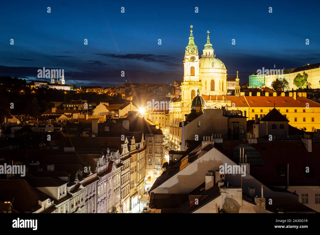 St Nicholas church towers over Mala Strana at nightfall, Prague. Stock Photo