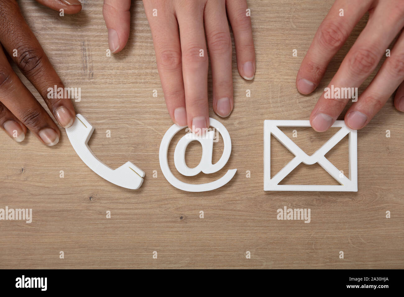 People Holding Email, Envelope, Phone, Icons On Wooden Desk Stock Photo