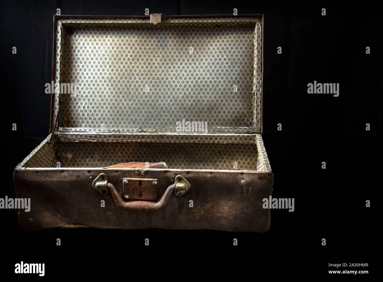 Very old open suitcase isolated on black background. Copy space. Stock Photo