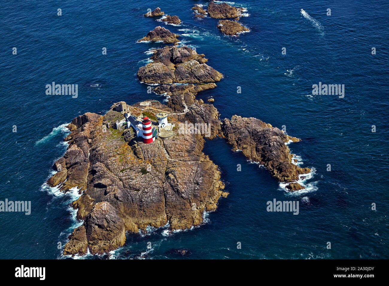 Aerial view of the red and white striped Casquets Lighthouse located on the rocky island group Les Casquets  close to Alderney in the English Channel Stock Photo