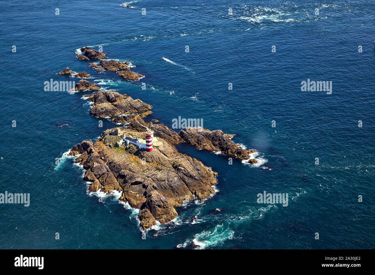 Aerial view of the red and white striped Casquets Lighthouse located on the rocky island group Les Casquets  close to Alderney in the English Channel Stock Photo