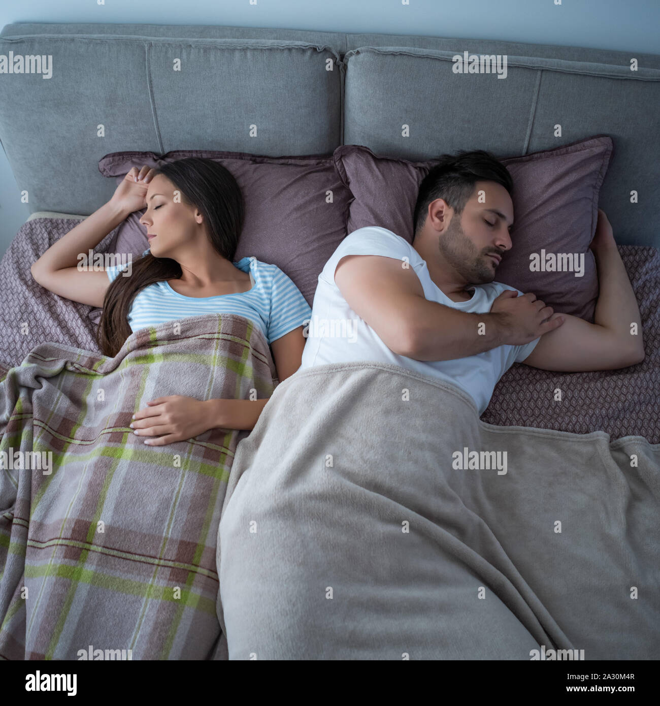 Young couple is sleeping in their bed. Stock Photo