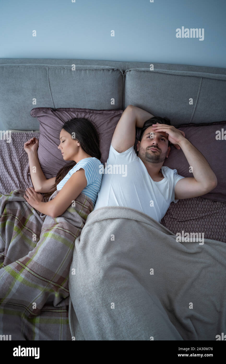 Young man is having trouble with sleep. Stock Photo