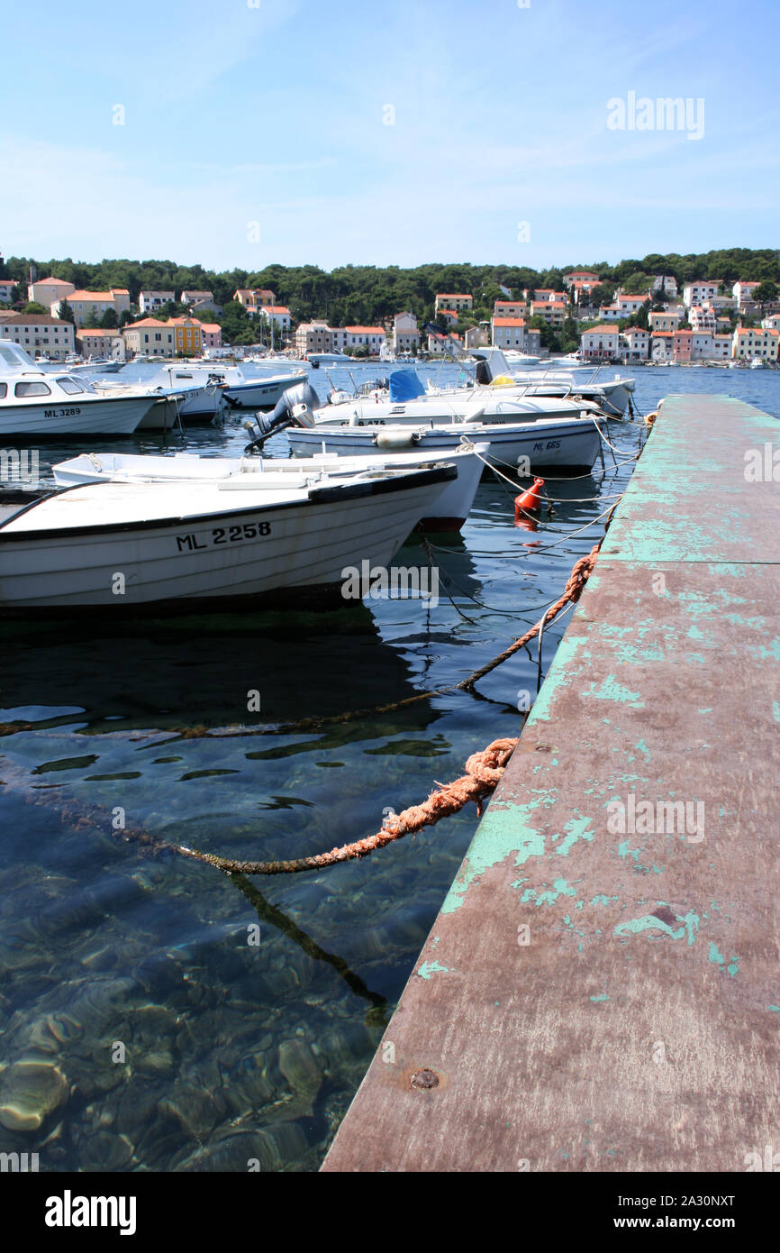 Dock full of boats with a town at the background. Stock Photo