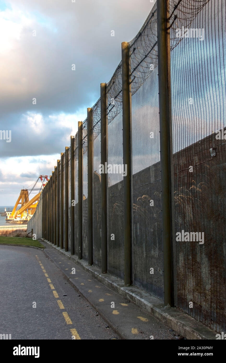 Prison walls and a fence with spikes on the blue sky background. Peterhead Prison Museum, Aberdeenshire, Scotland, United Kingdom. Stock Photo