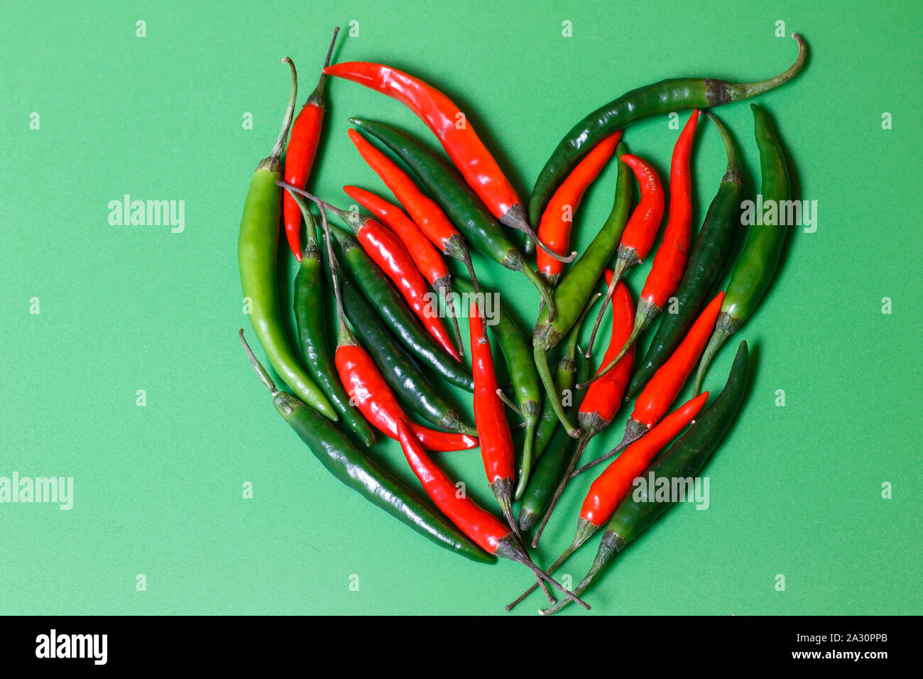 Peppers background with heart shape Stock Photo - Alamy