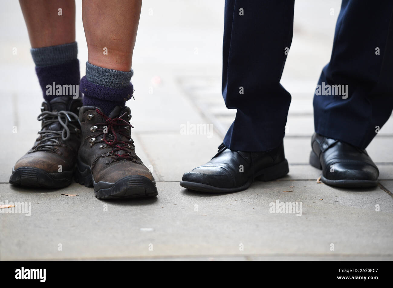 Detail of ex-Thomas Cook cabin crew member Rachel Murrell's walking boots (left), after arriving at Downing Street in London, to hand in a letter to Number 10 highlighting the plight of the workers, after walking 200 miles from Devon. Stock Photo