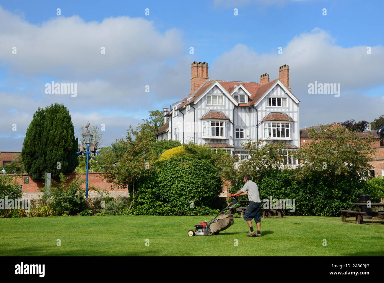 Gardener Cutting Grass in Riverside Gardens in front of the Luxurious 4-Star Arden Hotel Stratford-upon-Avon England UK Stock Photo