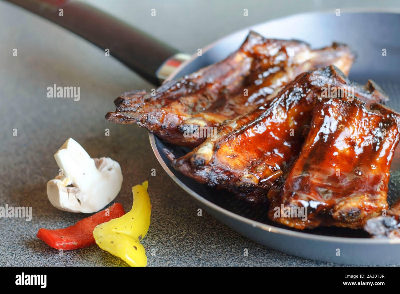 Ready to eat pork ribs on a frying pan. Stock Photo