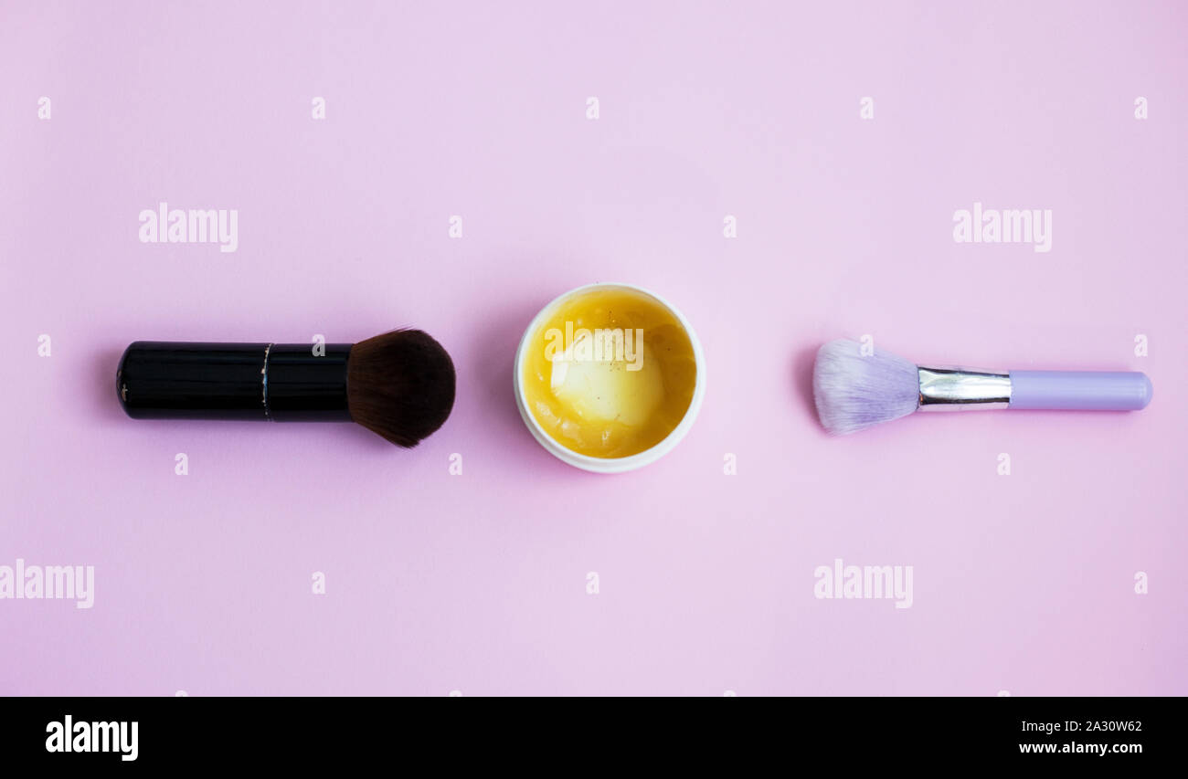 Makeup brushes and cosmetics on a pink background Stock Photo