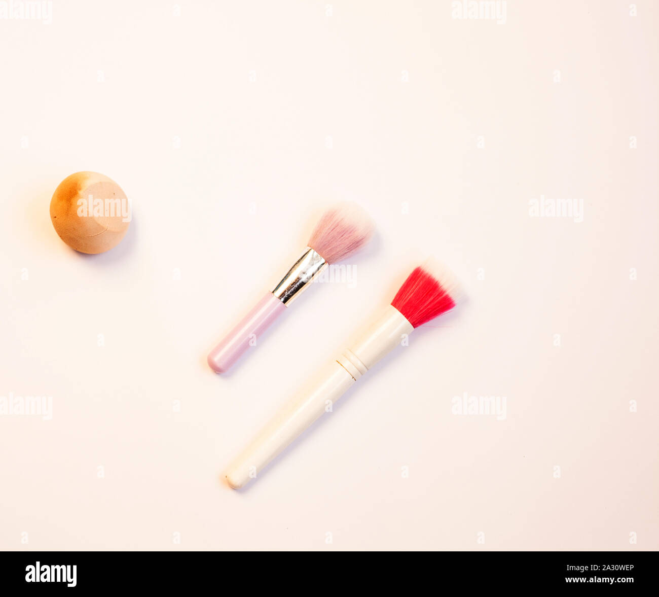 Makeup brushes and cosmetics on a pink background Stock Photo