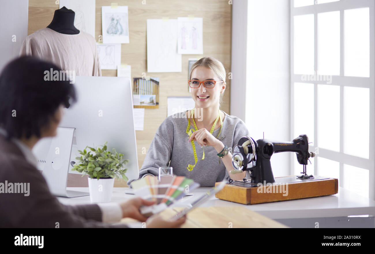 pretty dressmaker showing a new design to her client Stock Photo - Alamy