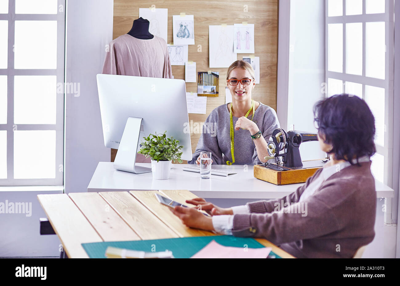 pretty dressmaker showing a new design to her client Stock Photo - Alamy