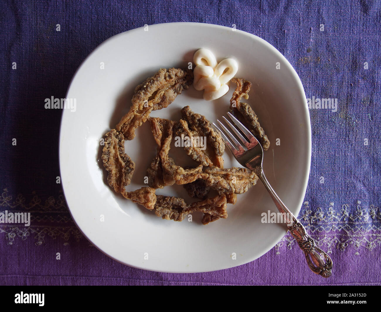 Coated and lightly fried Indiana wild morel mushrooms with dollop of mayonnaise presented on plate, Indiana, USA, July 30, 2019, © Katharine Andriotis Stock Photo