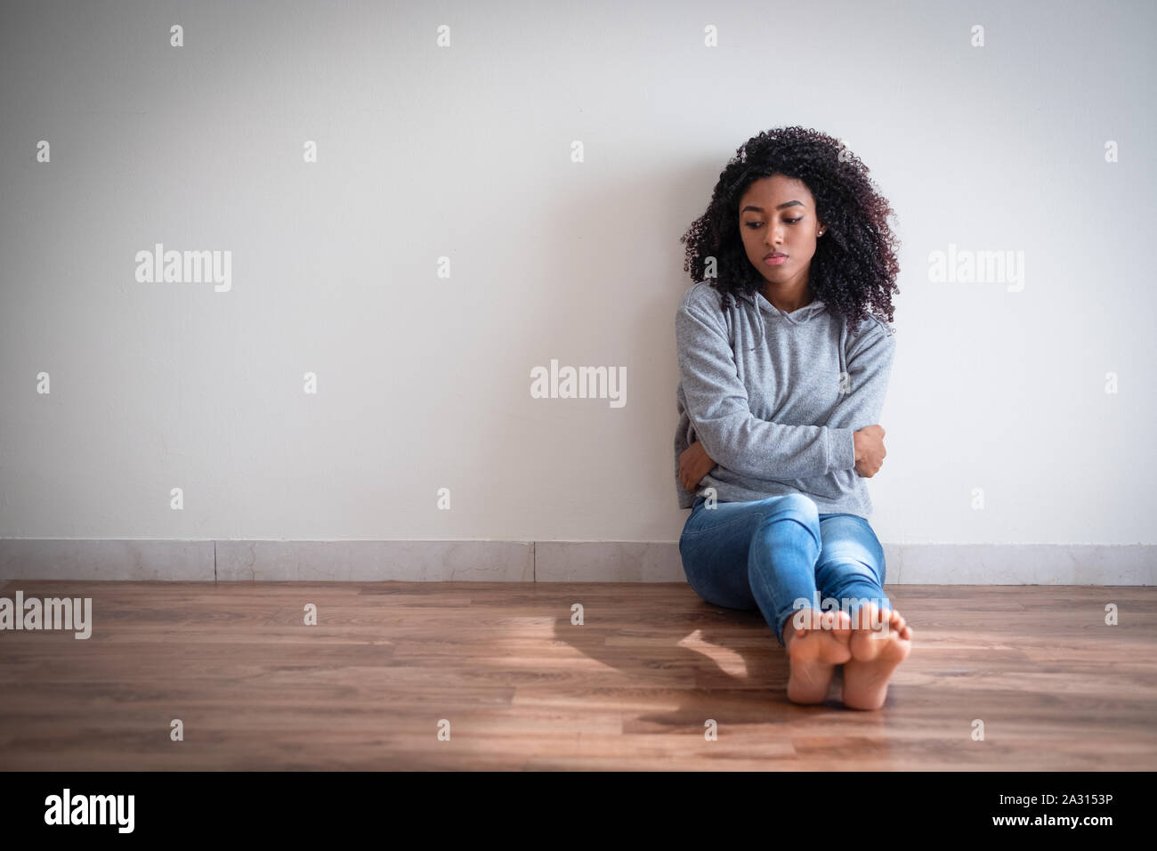 Depressed black young girl on the parquet floor Stock Photo
