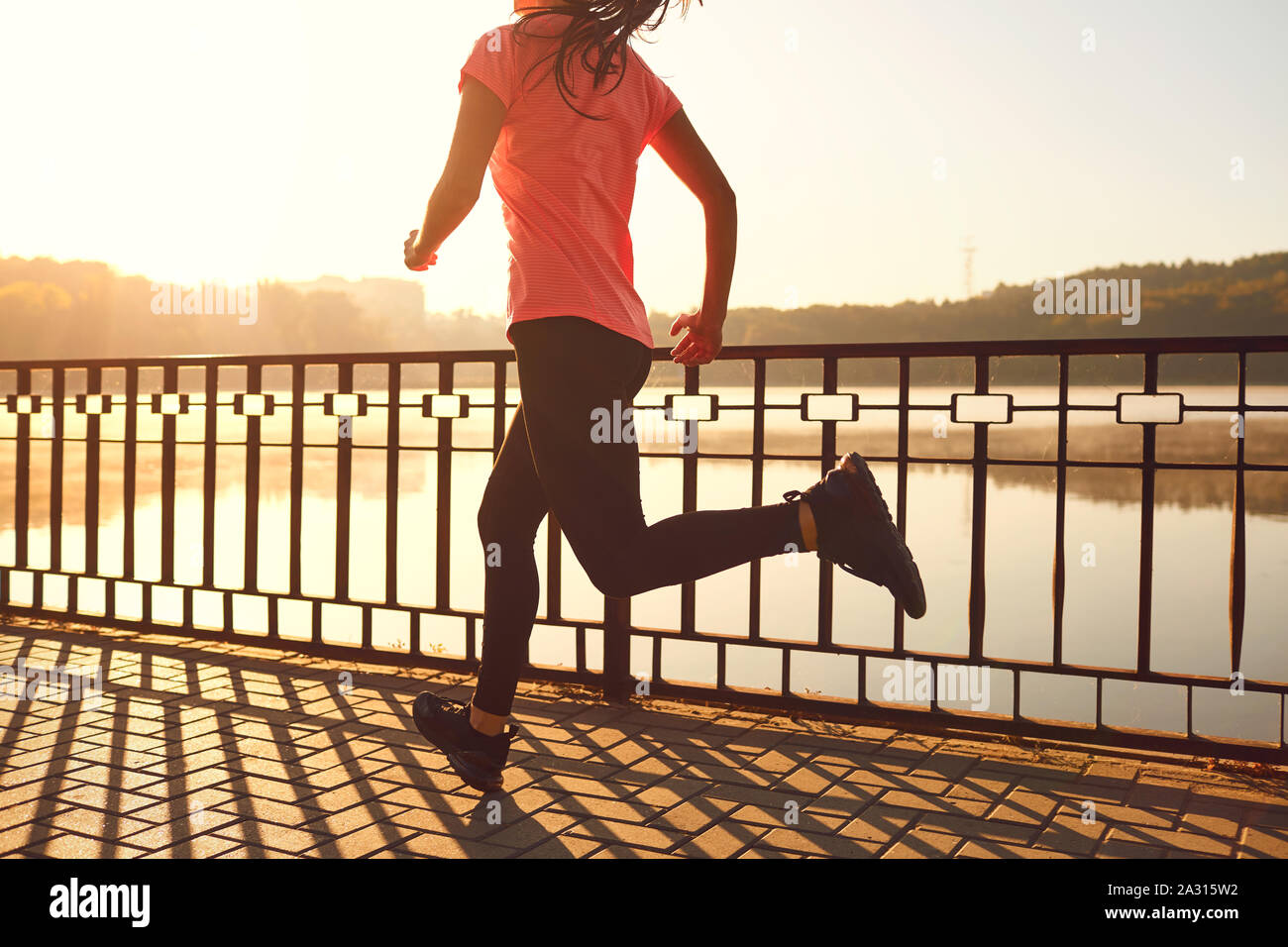 Runners legs run along the road by the lake in the park Stock Photo