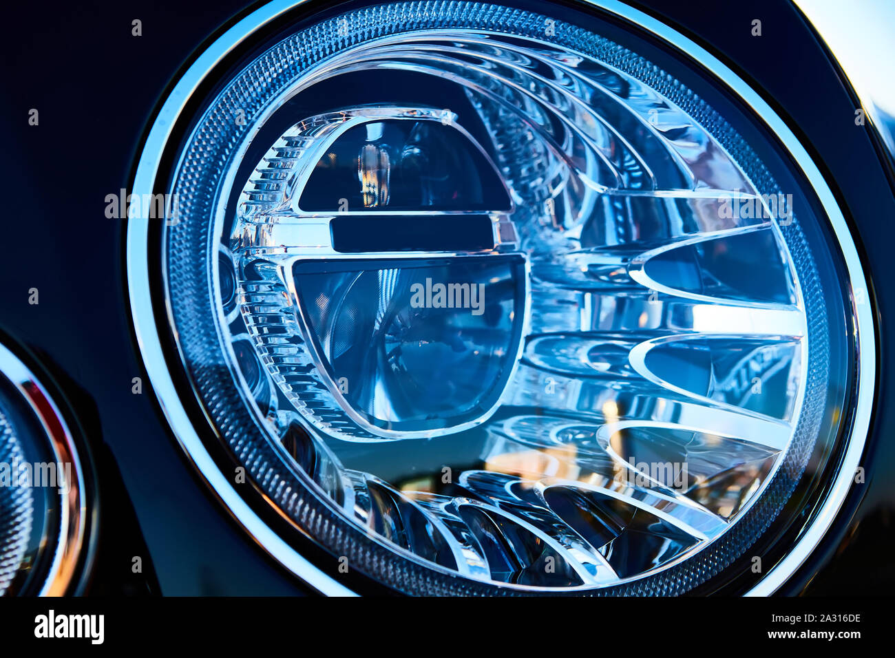 Headlight detail of luxury car. Closeup of sedan headlamp. Car