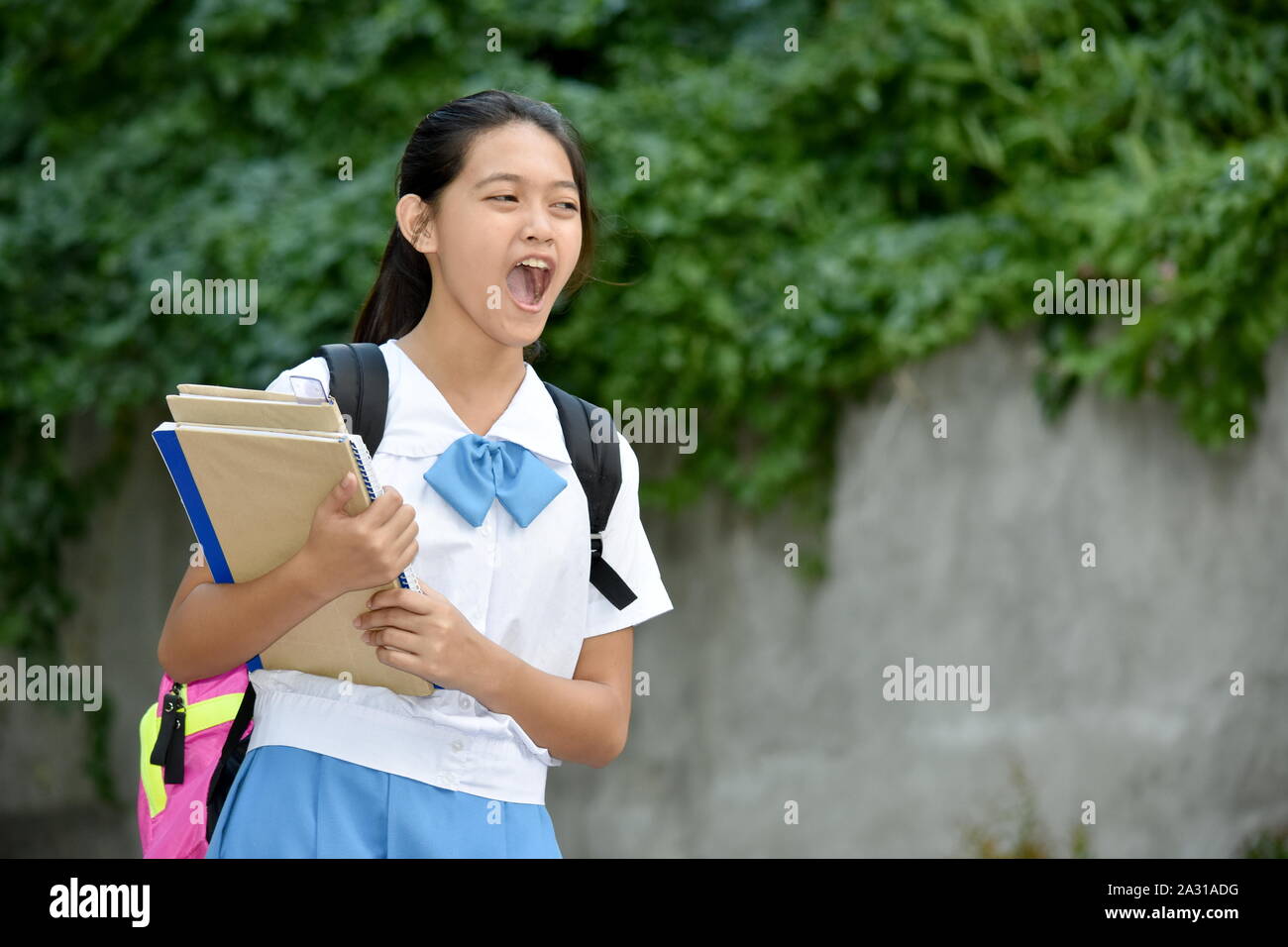 Youthful Filipina Girl Student Yelling With School Books Stock Photo