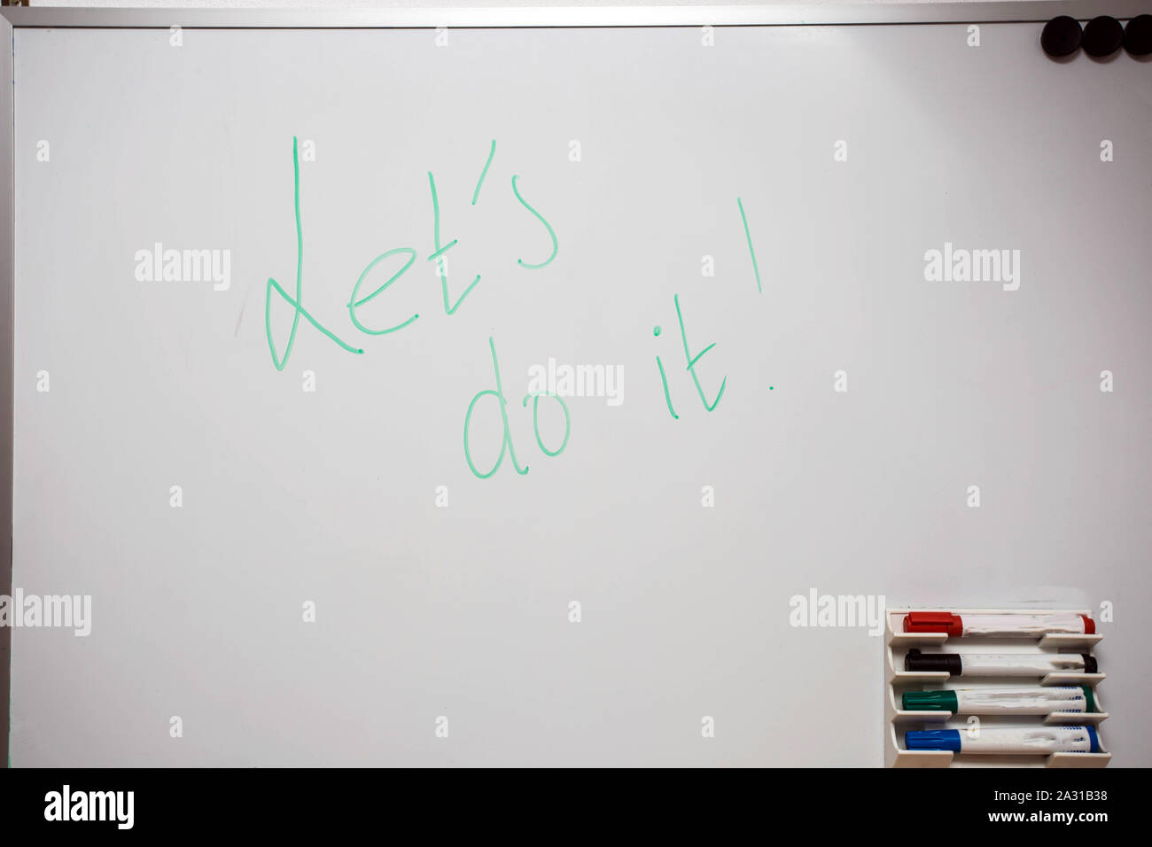 White board with colored markers and the words Let's do it written on
