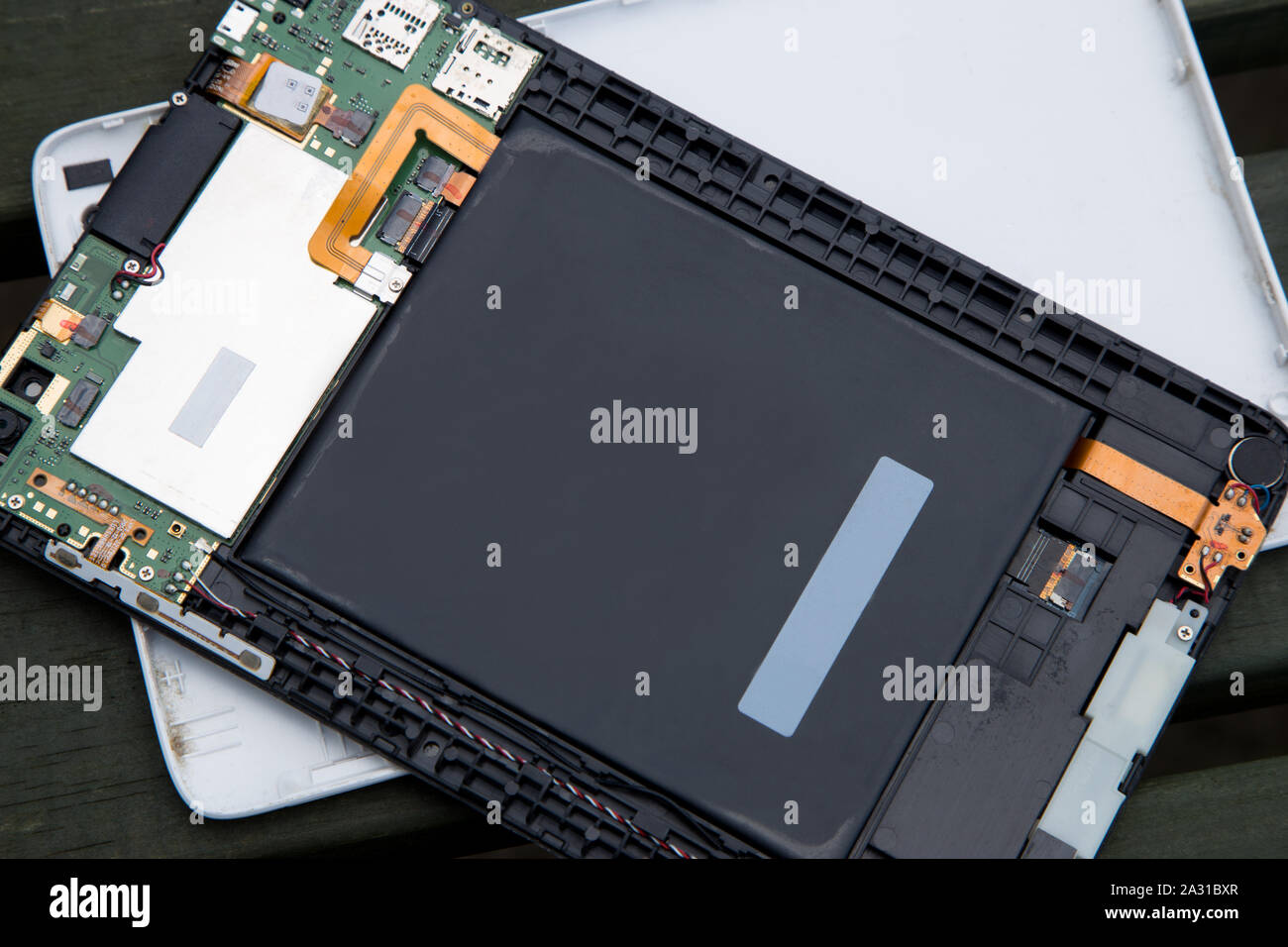 Dismantled broken electronic tablet device on a wooden bench Stock Photo