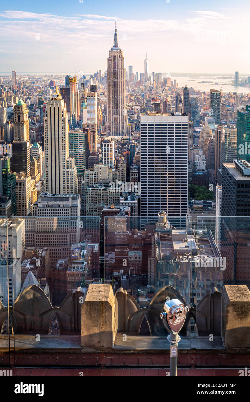 e of the iconic telescopes on Top of the Rock Observatory with the Empire State Building in the distance, New York City, USA. Stock Photo