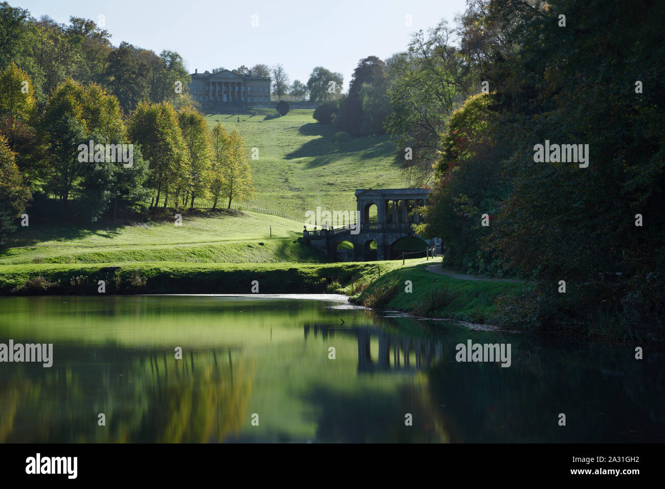 Prior Park Landscape Garden. View of the Palladian Bridge and the house from the lower lake. Bath. UK. Stock Photo