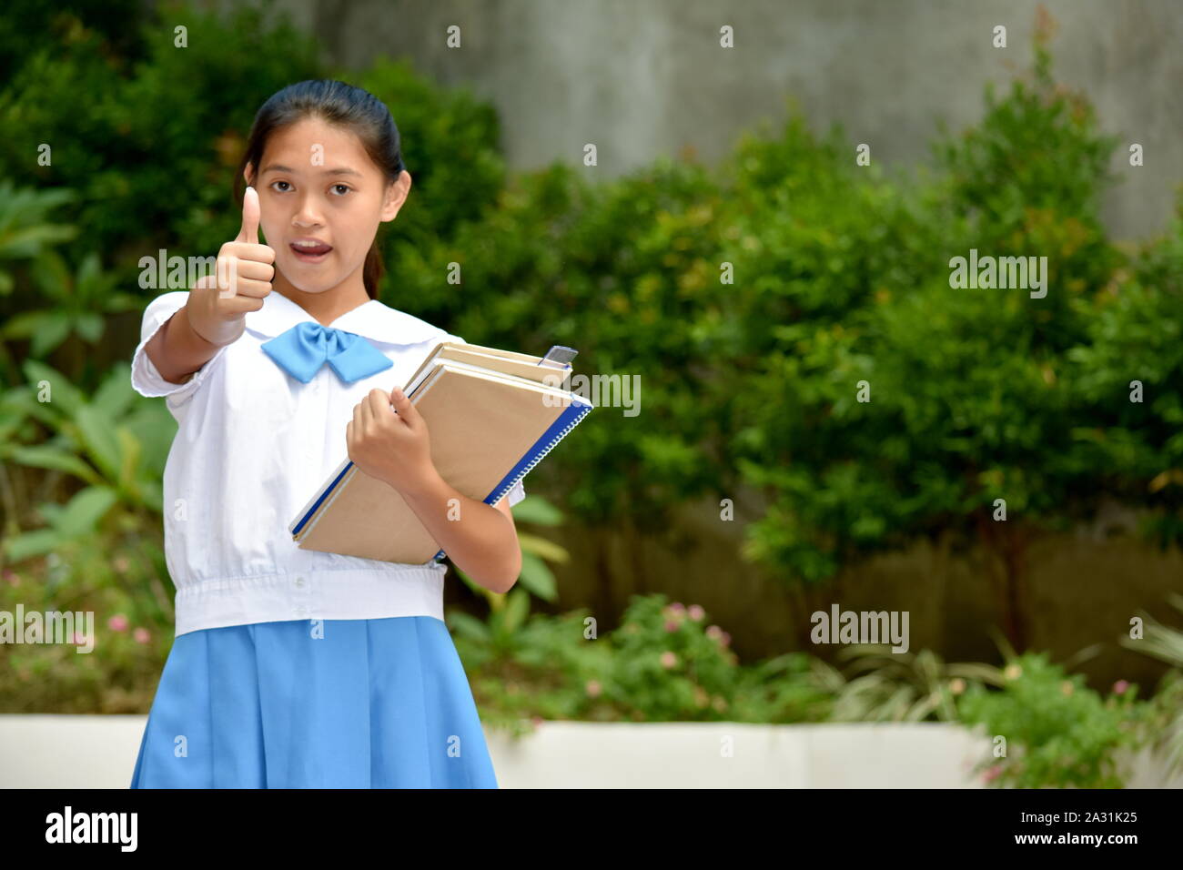 School Girl With Thumbs Up With School Books Stock Photo - Alamy