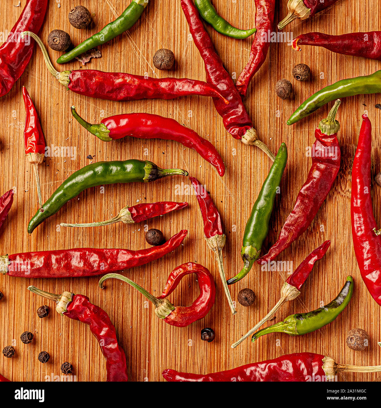 Red and green chili peppers on a wooden board Stock Photo - Alamy