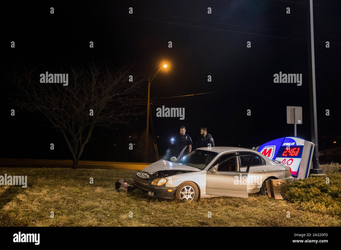 Police investigate at the scene of a car accident at the Marathon Gas station located at 1307 W 3rd St, before 2 a.m., Sunday, February 24, 2019 in Bloomington, Ind. The driver of the car fled the scene after hitting the sign, and police were looking for them in the area of Patterson. (Photo by Jeremy Hogan) Stock Photo