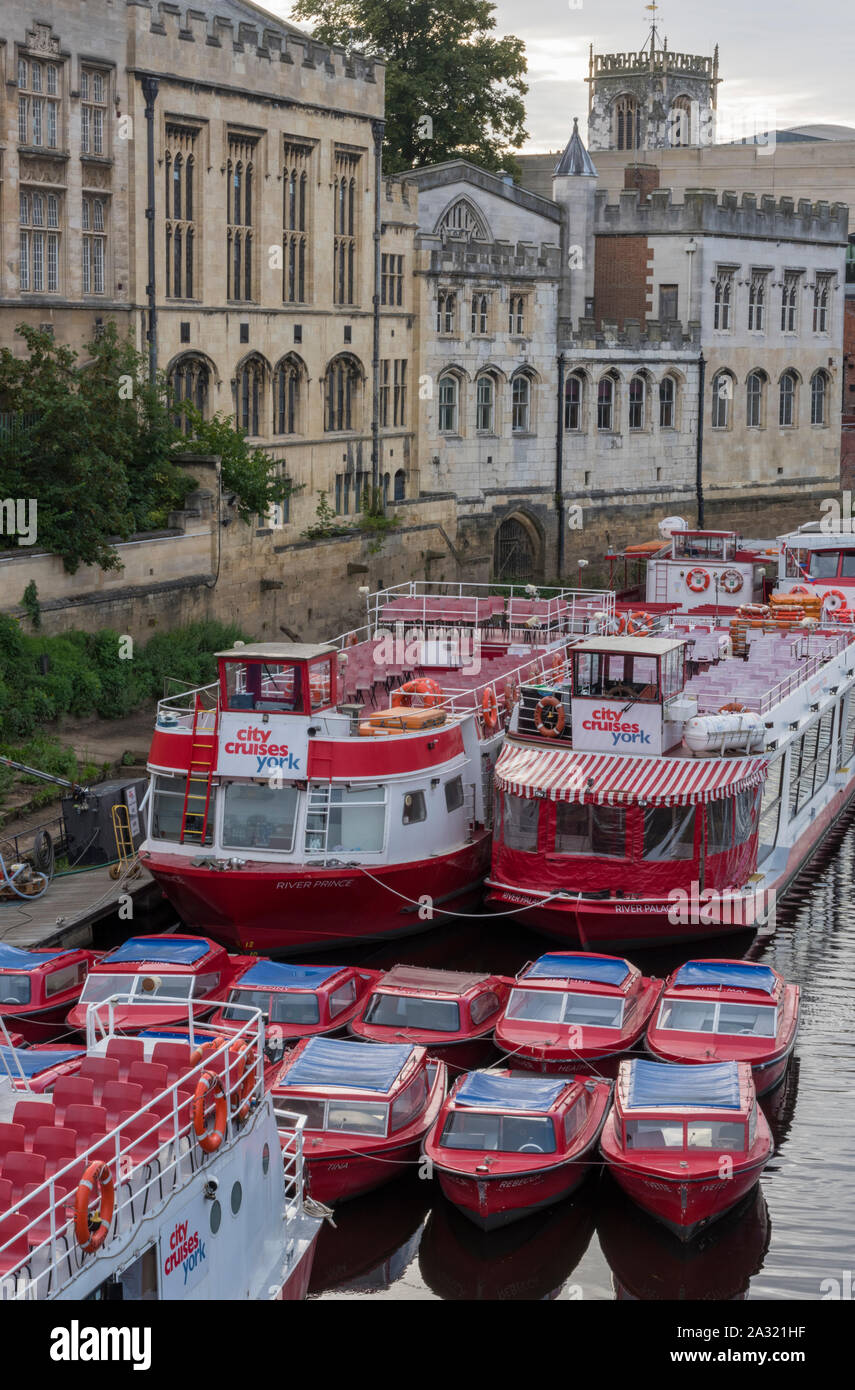 Pleasure boats and river cruisers tied up alongside on the banks of the river Ouse in York city centre, York, Yorkshire, uk. Stock Photo