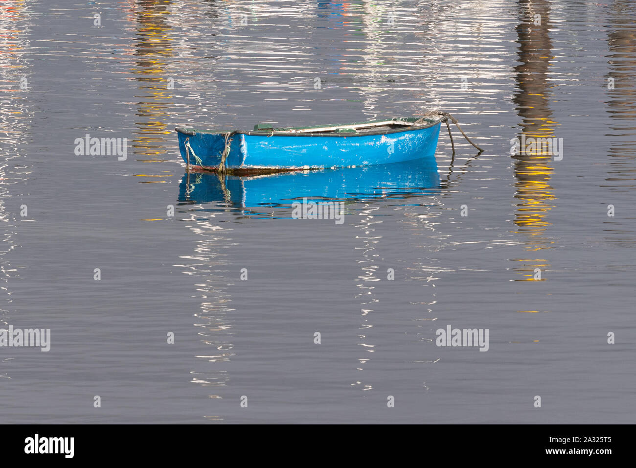empty blue rowing boat with reflections Stock Photo