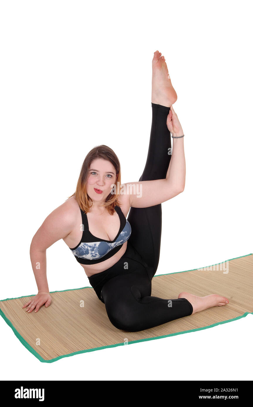 A beautiful young woman exercising on the floor with one leg up in the air, in a sports outfit, isolated for white background Stock Photo